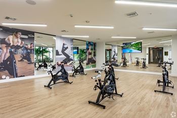 Our spin room with exercise bikes and a mirror wall at Hollywood Heights on the Boulevard Luxury Apartments in Hollywood, FL.